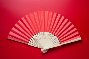 Chinese folding fan on red background - obrazy, fototapety, plakaty