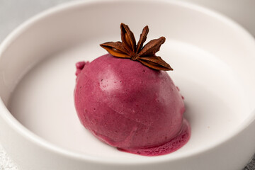 Berry ice cream, mulled wine ice cream, decorated with a flower of star anise
