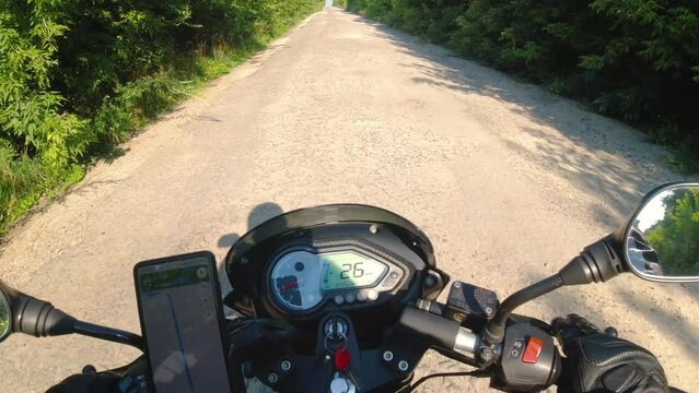 Motorcycle riding on the broken and damaged asphalt road, moto traveling in the summer, first person point of view, pov