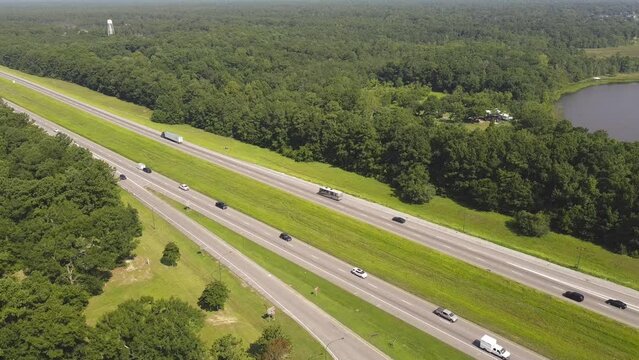 Busy traffic on Interstate Highway I-10 near Jackson County Rest Area West rest area with lush green tree from floodplain from Pascagoula River in Gautier, Lower Mississippi, USA