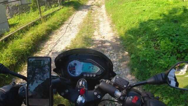 Motorcycle riding on the gravel country road, adventure moto traveling in the summer, first person point of view, pov