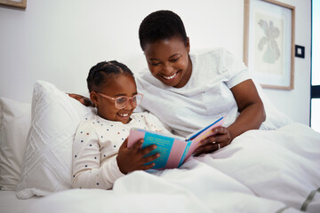 Relax, storytelling and book with mother and daughter in bedroom for education, fantasy and bedtime. Happy, learning and reading with woman and child in bed of black family home for knowledge