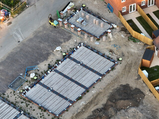 Aerial view looking on an area of new build housing construction on the edge of existing houses and...