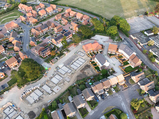 Aerial view looking on an area of new build housing construction on the edge of existing houses and...