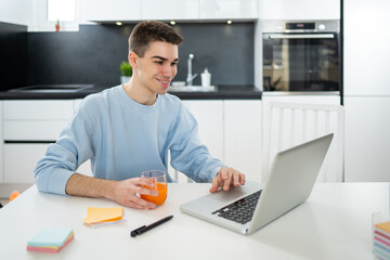 Male high school student having video calling on laptop at home. Online class, distant e-learning, video call concept.