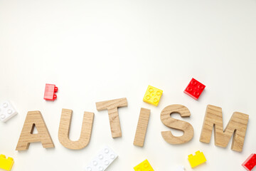 The word autism in wooden letters on a light background with blockss, place for text. World autism...