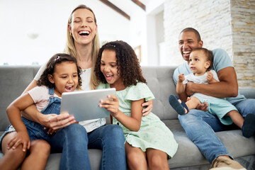 Tablet, laughing and family watching a video or funny, comedy or comic movie together in the living...