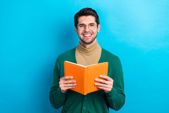 Photo of cheerful student young guy university wear green jumper beige turtleneck hold book reader isolated on blue color background