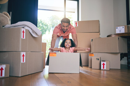 Father, child and box in new home for games, fun and freedom for bonding in real estate property. Happy dad, excited kid and portrait of girl play in cardboard boxes for race while moving to house