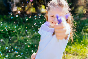 Cheerful girl with Down syndrome playing outdoors in the yard.Summer seasonal outdoor activities for children. The child smiles and enjoys summer fun.