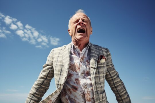 Medium shot portrait photography of a man in his 60s wincing in pain while holding his lower abdomen due to a urinary tract infection wearing a chic cardigan against a sky background 