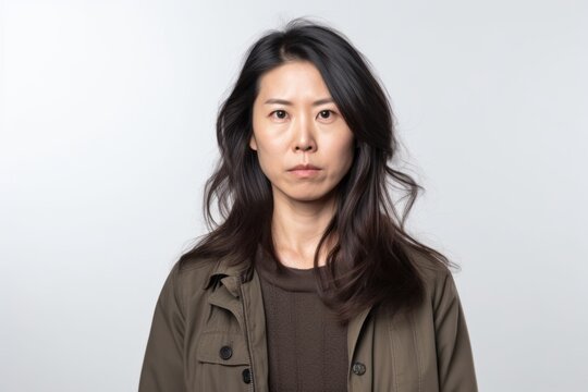 Group portrait photography of a woman in her 30s with furrowed brows and a tense expression due to hypertension wearing a chic cardigan against a white background 