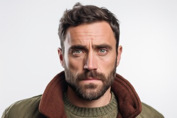 Obraz premium Close-up portrait photography of a man in his 30s with furrowed brows and a tense expression due to hypertension wearing a chic cardigan against a white background 