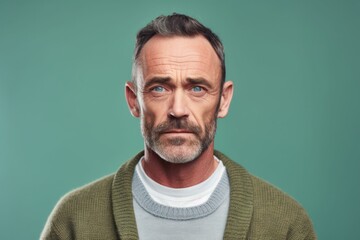 Obraz premium Close-up portrait photography of a man in his 40s with furrowed brows and a tense expression due to hypertension wearing a chic cardigan against a pastel or soft colors background 
