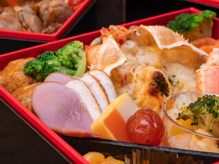 日本のおせち料理。かにグラタンや鴨肉ハム。