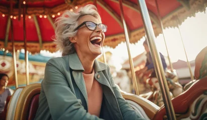 Fotobehang Joyful elderly woman riding in an amusement park © cherezoff