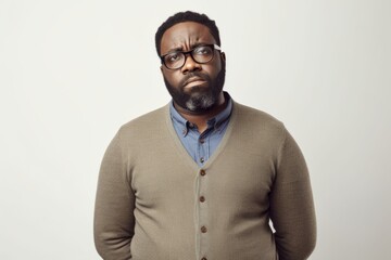Group portrait photography of a man in his 30s with a pained and tired expression due to fibromyalgia wearing a chic cardigan against a white background 