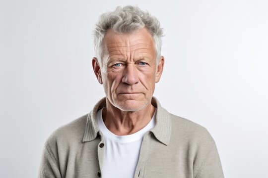 Lifestyle portrait photography of a man in his 50s with a pained and tired expression due to fibromyalgia wearing a chic cardigan against a white background 