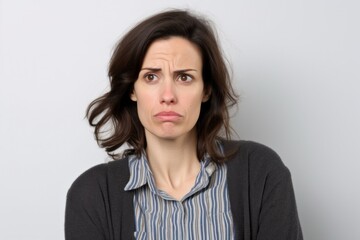 Medium shot portrait photography of a woman in her 30s showing tiredness and a worn-down expression due to chronic fatigue syndrome wearing a chic cardigan against a white background 