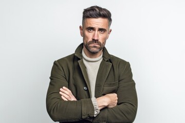 Lifestyle portrait photography of a man in his 30s showing tiredness and a worn-down expression due to chronic fatigue syndrome wearing a chic cardigan against a white background 