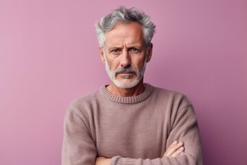 Medium shot portrait photography of a man in his 50s showing tiredness and a worn-down expression due to chronic fatigue syndrome wearing a cozy sweater against a pastel or soft colors background 