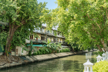 Fototapeta na wymiar Retro old buildings and canal river with green forest in Bangkok, Thailand