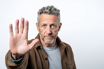 Lifestyle portrait photography of a man in his 40s with a trembling hand and pained expression due to Parkinson disease wearing a chic cardigan against a white background 