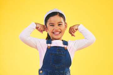 Smile, portrait and girl child with arm flex in studio for confidence, strong and power on yellow...