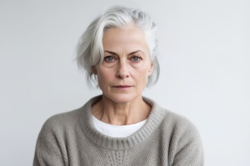 Close-up portrait photography of a woman in her 50s with a somber and deeply sad expression due to major depression wearing a chic cardigan against a white background 