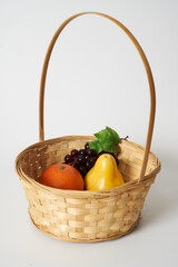 orange  grape and pear in a basket  white background