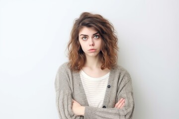 Obraz premium Medium shot portrait photography of a woman in her 20s looking anxious and fidgety due to generalized anxiety disorder wearing a chic cardigan against a white background 