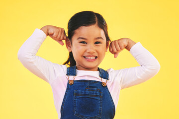 Happy, portrait and girl child with arm flex in studio for confidence, strong and power on yellow...