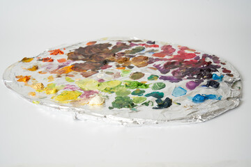 colorful oil paints on painters palette on white background