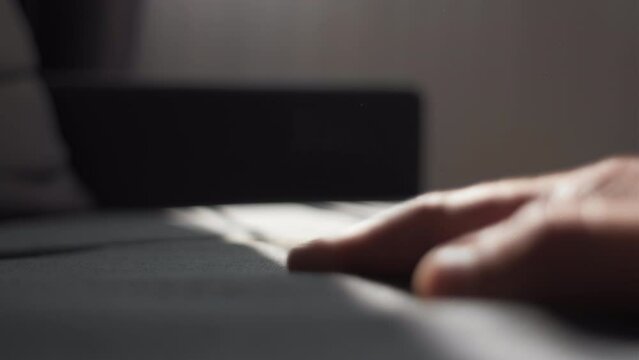 Close-up of unrecognizable young man hand pressing light sofa for comfortable sitting at home or hotel. Checking hardness and softness. Choice of best type and quality. Selective focus