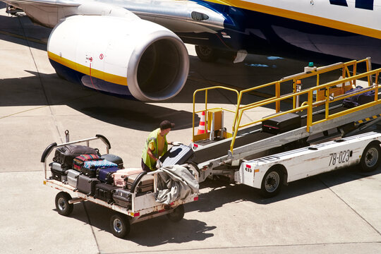 homme mettant des bagages dans la soute d'un avion &agrave; l'a&eacute;roport 