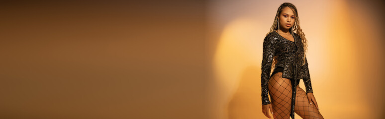 banner, african american woman with tattoo on leg posing in fishnet tights on yellow background