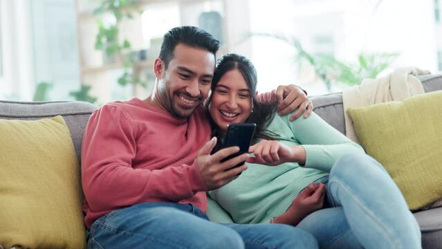 Happy, hug and couple on a sofa with phone for social media, streaming or video subscription in their home. Love, embrace and woman with man and smartphone in a living room for online communication