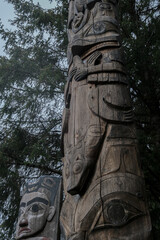 Tlingit totem poles and lush woods tree nature landscape scenery in Sitka Historical Park hiking...