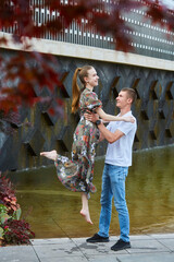 Beautiful young girl and guy in the park. Spring or summer day. Photo shoot for a young couple