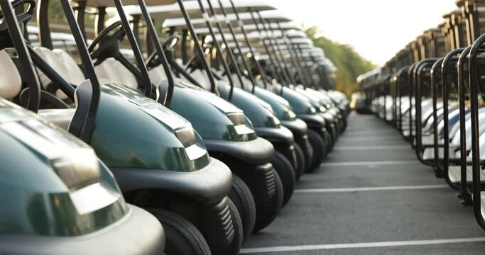 Many golf carts for golf player on a golf course. golf course carts cars at luxury resort sport venue in neat line row.