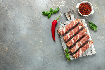 Thin bacon rolls with minced meat on a wooden board, banner, menu, recipe place for text, top view