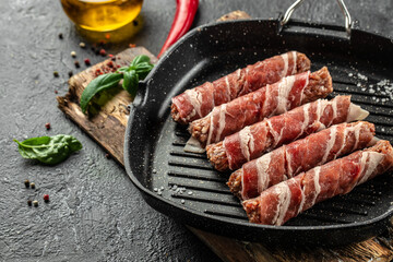 Bacon wrapped burger dogs. pork mince wrapped with delicious pieces of bacon in pan. Food recipe...
