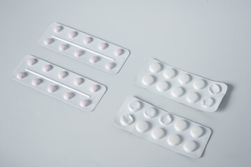 Painkillers or drugs in plastic box on a white surface.