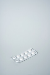 Painkillers or drugs in plastic box on a white surface.