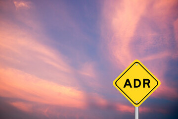 Yellow transportation sign with word ADR (Abbreviation of adverse drug reaction) on violet color sky background