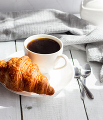 A cup of coffee and croissants. on white wooden. breakfast. Morning