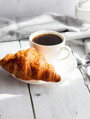 A cup of coffee and croissants. on white wooden. breakfast. Morning