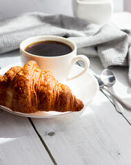 A cup of coffee and croissants. on white wooden. breakfast. Morning