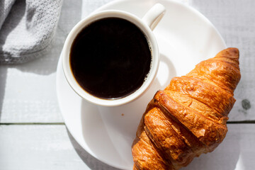 A cup of coffee and croissants. on white wooden. breakfast. Morning