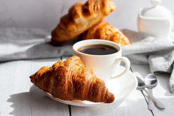 A cup of coffee and croissants. on white wooden. breakfast. Morning